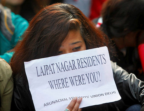 One of the students from northeastern states showing a placard at a protest demanding justice for 20-year-old Nido Tania, at Lajpat Nagar Police Station in New Delhi on Saturday. PTI Photo