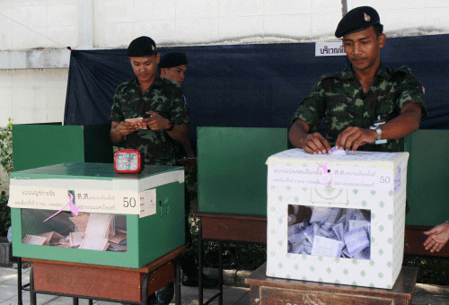 Thai soldiers cast their ballots at a polling station in Bangkok February 2, 2014. Thailand went to the polls under heavy security on Sunday in an election that could push the divided country deeper into political turmoil and leave the winner paralysed for months by street protests, legal challenges and legislative limbo. REUTERS
