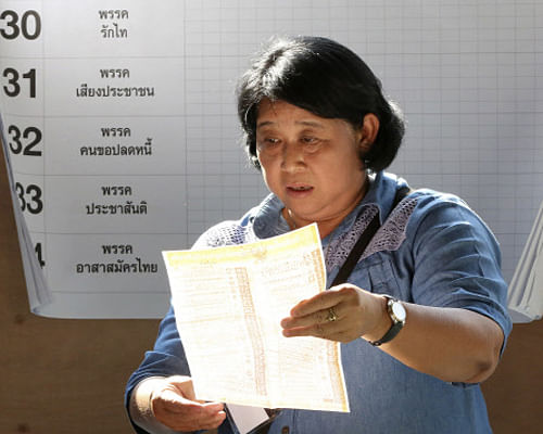 An election official checks a ballot during a vote counting after the general election in Bangkok. AP Photo