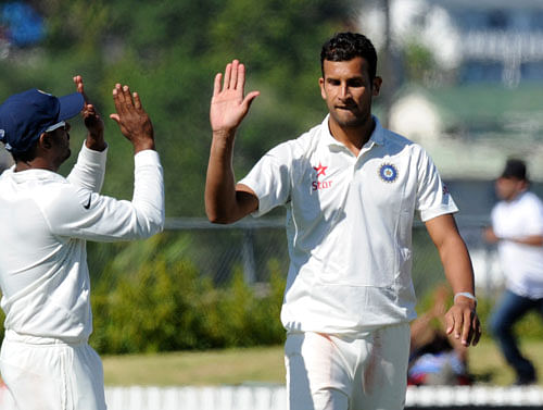 Iswhar Pandey, right, high fives after dismissing New Zealand XI's Ili Tuagaga on the first day of a pre test warm up cricket match at Cobham Oval in Whangarei, New Zealand, Sunday, Feb. 2, 2014. AP