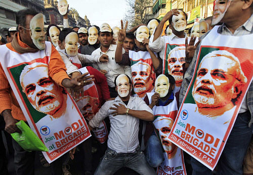 Supporters of Bharatiya Janata Party (BJP) wear masks and posters of Narendra Modi, prime ministerial candidate for BJP and Gujarat's chief minister, as they attend a party campaign rally in Kolkata February 1, 2014. REUTERS