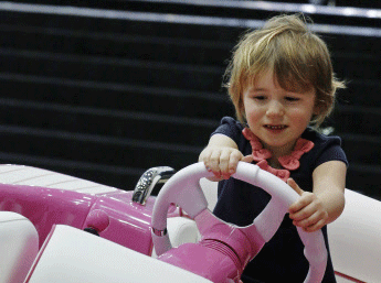 A girl plays on the customised pink Williams Performance Turbojet 325, to be auctioned in aid of breast cancer treatment, at the London Boat Show. Reuters