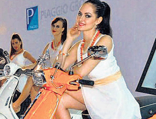 Models pose astride the scooters Liberty 125 3V, Vespa S and Vespa 946 which Piaggio Vehicles Private Ltd unveiled at the 12th Auto Expo 2014 in Greater Noida on Wednesday. PTI