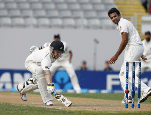 New Zealand's century maker Brendon McCullum prods backwards to make his ground after Cory Anderson hit the ball towards the stumps watched by India's Zaheer Khan (R) on day one of the first international test cricket match at Eden Park in Auckland February 6, 2014. REUTERS