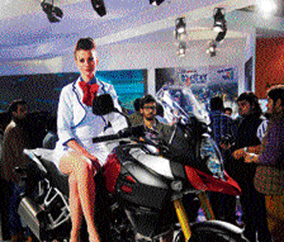 A model poses with a newly launched bike at the Suzuki stall during the 12th Auto Expo 2014 on Thursday. PTI