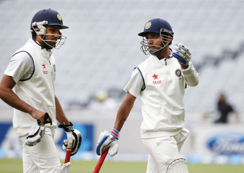 India's Ajinkya Rahane (R) and Rohit Sharma (L) chat as they leave the field due to bad light on day two of the first international test cricket match against New Zealand, at Eden Park in Auckland February 7, 2014. REUTERS