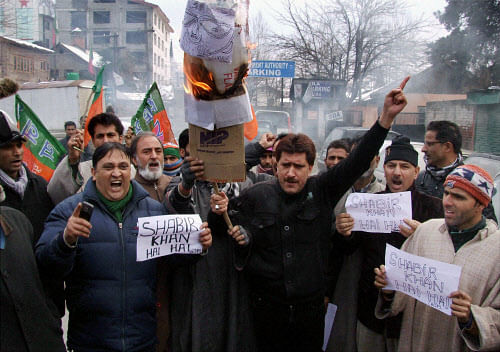 Bharatiya Janta Party (BJP) leaders and workers burn the effigy of Jammu and Kashmir Health Minister Shabir Ahmad Khan who was booked by police in connection with a molestation case, during a protest at Lal Chowk in Srinagar on Friday. PTI Photo