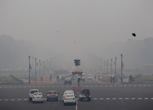 Smog and fog envelop the Rajpath, the ceremonial boulevard, behind, as a police man, center, controls traffic in the morning in New Delhi. On bad days in India's congested capital, the air is so murky it slows traffic to a crawl because visibility is so poor. Conversations are punctuated with rasping coughs. Weak bands of sunlight filter through a grainy sky. AP