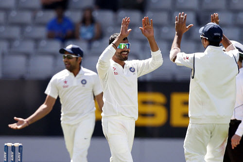 Ravindra Jadeja (C) celebrates dismissing New Zealand's Tim Southee on day three of the first international test cricket match at Eden Park in Auckland, February 8, 2014. REUTERS