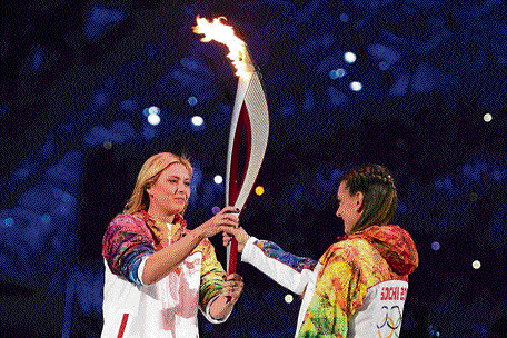 From one champ to the other: Tennis star Maria Sharapova hands over the Olympic torch to pole vault legend Yelena Isinbayeva at the Winter Olympics opening ceremony. AFP