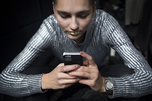 A model uses a mobile phone before presenting a creation from the Son Jung Wan 2014 Fall/Winter collection during New York Fashion Week in New York February 8, 2014. REUTERS/Andrew Kelly