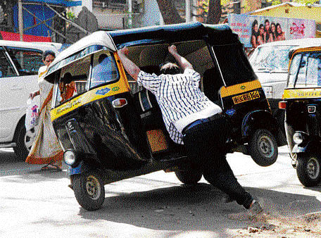 An MNS supporter tries to overturn an autorickshaw during a protest against toll tax at Thane in Mumbai on Wednesday. PTI