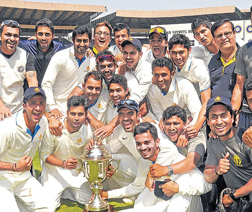 Jubilant Karnataka players pose with the Irani Cup at the Chinnaswamy Stadium  on Wednesday. DH Photo/ SK Dinesh