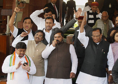 Congress MPs from Telangana region shouting slogan at Parliament House during the extended winter session in New Delhi on Wednesday. PTI Photo