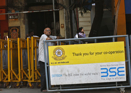 A man looks at a screen across the road displaying the Sensex on the facade of the Bombay Stock Exchange building in Mumbai. Reuters.