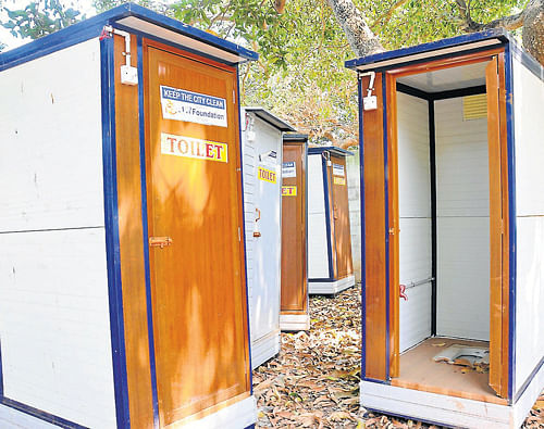 Mobile toilets that were donated to Mysore City Corporation have been discarded at VVWW premises. DH Photo