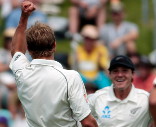 New Zealand's Neil Wagner (L) celebrates the dismissal of India's Virat Kohli (not seen) with BJ Watling (R) during the first innings on day two of the second international test cricket match at the Basin Reserve in Wellington February 15, 2014. REUTERS