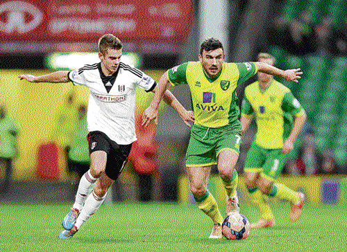 tense times:  Norwich City's Robert Snodgrass (right) battles for the ball with Fulham's Alex Kacaniklic.  Norwich is among the teams battling relegation. ap