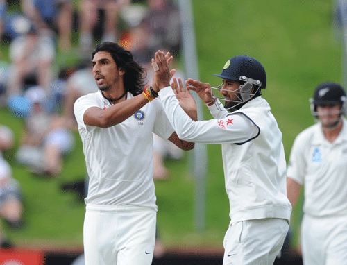 Ishant Sharma, left, celebrates with Cheteshwar Pujara after dismissing New Zealand's Hamish Rutherford for 12 on the 1st day of the 2nd cricket test, Basin Reserve, Wellington, New Zealand, Friday, February 14, 2014. AP