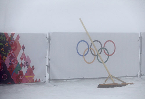 A broom is seen leant against a barrier bearing the Olympic rings as thick fog surrounds the Laura Cross Country Ski and Biathlon Center at the Sochi 2014 Winter Olympic Games, February 17, 2014. Organisers of the Sochi Olympics defied the odds when they battled unusually warm temperatures for a week but they were helpless against a winter fog that caused events to be postponed on Monday. The men's biathlon 15km mass start was called off for a second straight day due to thick fog, which also forced the postponement of the men's snowboard cross competition. REUTERS