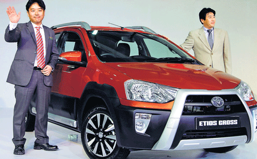 Toyota Motor Corporation Chief Engineer Akio Nishimura (right) and MD Naomi Ishii, pose with Etios Cross during its unveiling at the 12th Indian auto Expo. AP