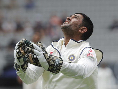 MS Dhoni keeps an eye on the ball as he missed an attempt to take against catch to dismiss New Zealand's Brendon McCullum on the second day of the first cricket test at Eden Park in Auckland, New Zealand, Friday, Feb. 7, 2014. (AP Photo/SNPA, Ross Setford)