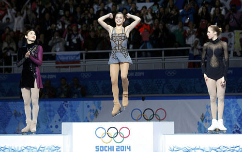 Russia's Adelina Sotnikova celebrates in first place, Korea's Yuna Kim stands in second place and Italy's Carolina Kostner stands in third place on the podium during the Figure Skating Women's free skating Program at the Sochi 2014 Winter Olympics, February 20, 2014. REUTERS/
