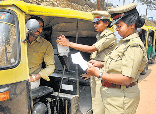 The inspectors of the legal metrology department checking an auto meter. DH Photo by Janardhan bk