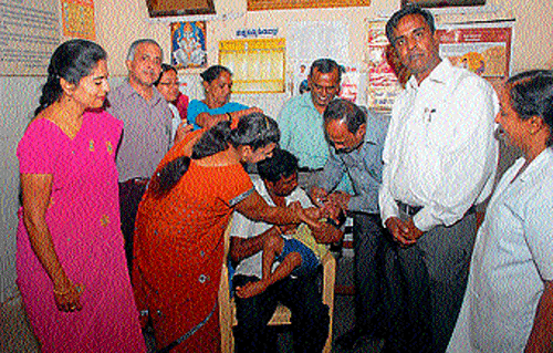 District Health Officer H T Puttaswamy administers polio drops to a child during the second phase drive, in Mysore, on Sunday. dh photo