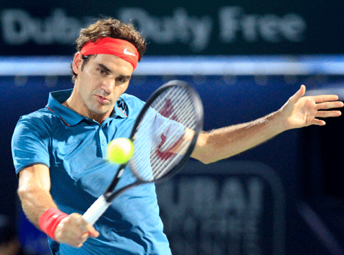 Roger Federer of Switzerland returns the ball to Benjamin Becker of Germany during their men's singles match at the ATP Dubai Tennis Championships, February 24, 2014. REUTERS