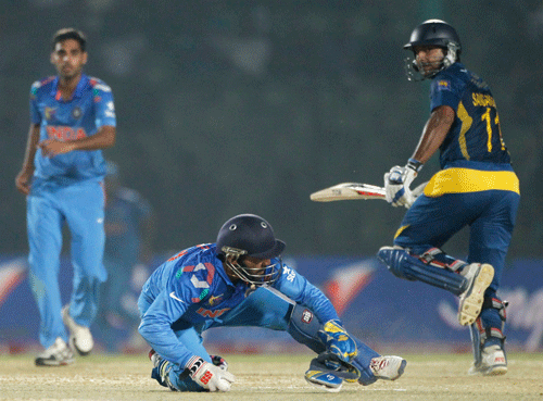 Sri Lanka's Kumar Sangakkara (R) runs between the wickets as India's wicketkeeper Dinesh Kartik jumps to catch a ball during their Asia Cup 2014 one-day international (ODI) cricket match in Fatullah February 28, 2014. REUTERS