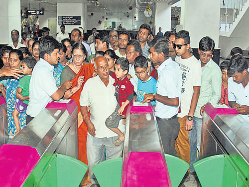 People wait eagerly in front of the entry points at the Sampige Road Metro Station. DH Photo/Savitha B R