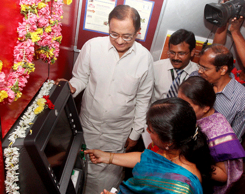 Union Finance Minister P Chidambaram and Padmini Gopinath, Secretary Department of Posts look on as a customer withdraws money from the India's first Postal ATM which was inaugurated by the Minister at T. Nagar Post Office in Chennai on Thursday. PTI Photo