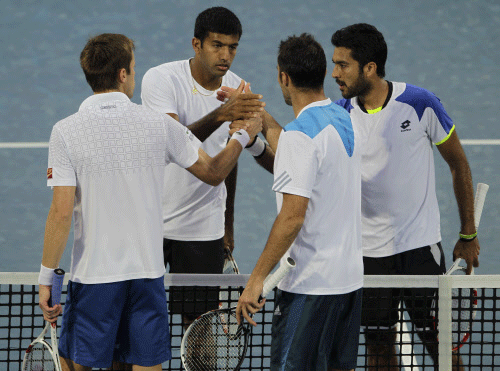 Rohan Bopanna of India, second left, and Aisam-Ul- Haq Qureshi of Pakistan, right, shakes hands with Daniel Nestor of Canada and Nenad Zimonjic of Serbia after Bopanna and Qureshi won the doubles final match of the Dubai Duty Free Tennis Championships in Dubai, United Arab Emirates, Saturday, March 1, 2014. (AP Photo/Kamran Jebreili)