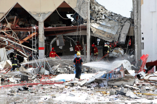Firemen work at the site of an explosion in Doha, Qatar, Thursday, Feb. 27, 2014. A apparent gas explosion Thursday at a restaurant near a filling station in the Qatari capital killed a dozen people and wounded several more, emergency services officials in the energy-rich Gulf nation said. AP photo