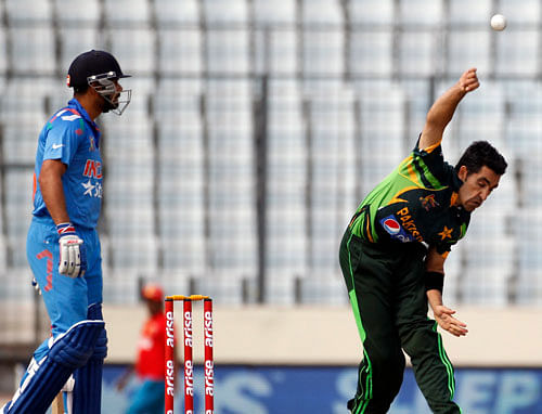 Pakistan's Umar Gul bowls as Virat Kohli (L) watches during their one-day international (ODI) cricket match in Asia Cup 2014 in Dhaka March 2, 2014. REUTERS