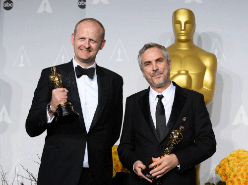 Alfonso Cuaron, right, and Mark Sanger pose in the press room with the award for best film editing for 'Gravity' during the Oscars at the Dolby Theatre on Sunday, March 2, 2014, in Los Angeles.  AP photo