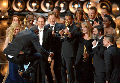 Director Steve McQueen, left, celebrates with the cast and crew of '12 Years a Slave' as they accept the award for best picture during the Oscars at the Dolby Theatre on Sunday, March 2, 2014, in Los Angeles. AP photo