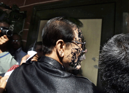 Chairman of Sahara India Pariwar Subrata Roy, his face smeared with ink thrown by a lawyer, walks into the Supreme Court in New Delhi, India, Tuesday, March 4, 2014. A lawyer threw ink at the top Indian businessman as he arrived at India's highest court Tuesday to face charges that his company failed to return billions of dollars to investors. Roy's Sahara conglomerate is well known throughout India because it co-owns a Formula One team and sponsored the Indian cricket team until recently. AP photo