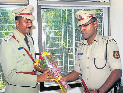 New Superintendent of Police Sharanappa S D (left) takes charge from outgoing SP Shantanu Sinha at SP&#8200;office in Mangalore on Wednesday. DH Photo