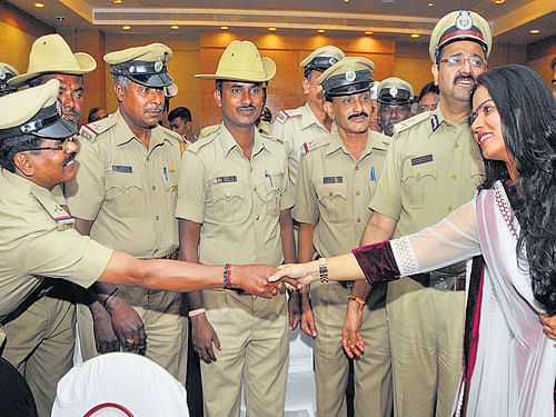 Actor Sharmila Mandre greets policemen who received 'Knights in Khaki' award at an event in the City on Wednesday. City Police Commissioner Raghavendra H Auradkar looks on. DH Photo