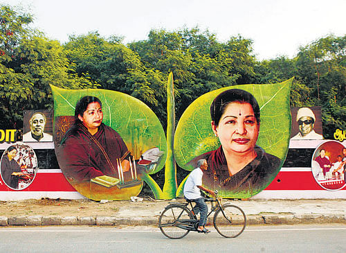 gearing up: A cyclist rides past pictures of Tamil Nadu Chief Minister and AIADMK leader Jayalalitha in Chennai on  Wednesday. AP