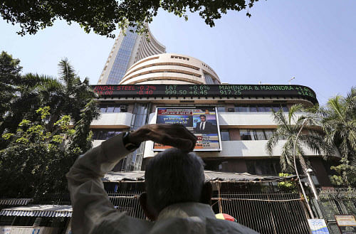 A man looks at a screen across the road displaying the Sensex on the facade of the BSE building in Mumbai. Reuters.