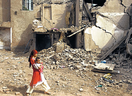 A woman walks past demolished houses in Kashgar. The official narrative of the modernisation project justified tearing down 65,000 homes and resettling 220,000 Uighur residents as crucial to improving their lives. NYT