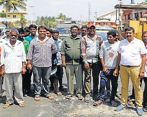 Residents of Vivekananda Layout, in Kushalnagar, Kodagu district, interrupt works on the Bypass Road and stage a protest, alleging that the negligence of the officials of KRDCL was the cause for their water woes, on Thursday. DH Photo