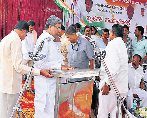 Police personnel ask a few Congress workers to get down from the stage, as a portion of it collapsed while Chief Minister Siddaramaiah was addressing a party workers meeting, in Periyapatna, Mysore district, on Thursday. DH Photo
