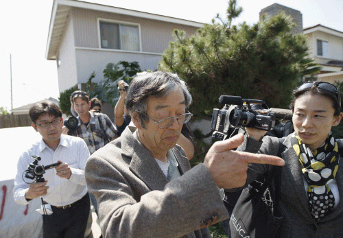 A man widely believed to be Bitcoin currency founder Satoshi Nakamoto is surrounded by reporters as he leaves his home in Temple City, California March 6, 2014. REUTERS