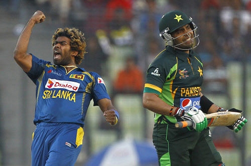 Sri Lanka's Lasith Malinga, left, celebrates taking the wicket of Pakistan's Umar Akmal, right, during their Asia Cup final cricket match in Dhaka, Bangladesh, Saturday, March 8, 2014.  AP photo