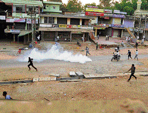 Police burst tear gas shell to disperse a mob at Kalladka in Dakshina Kannada district on Saturday. dh photo