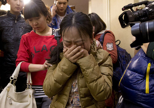 A Chinese relative of passengers aboard a missing Malaysia Airlines plane, center, cries as she is escorted by a woman while leaving a hotel room for relatives or friends of passengers aboard the missing airplane, in Beijing, China Sunday, March 9, 2014. Planes and ships from across Asia resumed the hunt Sunday for the Malaysian jetliner missing with 239 people on board for more than 24 hours, while Malaysian aviation authorities investigated how two passengers were apparently able to get on the aircraft using stolen passports. (AP Photo)